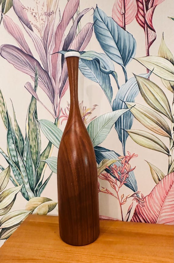 Hand-turned teak vessel that sits somewhere between sculpture and vase — the kind of object that anchors a credenza.