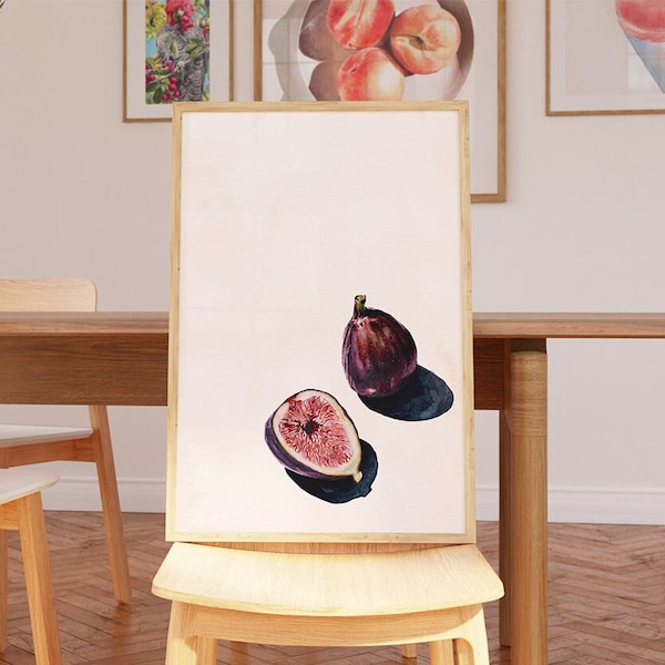 Pode incluir: Uma impressão emoldurada de uma pintura em aquarela de dois figos, um inteiro e outro cortado ao meio, sobre um fundo branco.