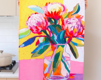 Può includere: Una stampa floreale colorata con un bouquet di fiori rosa e rossi in un vaso trasparente. Lo sfondo è diviso in sezioni gialle, bianche e rosa. La firma dell'artista, "julia ockert", è visibile in basso a sinistra.