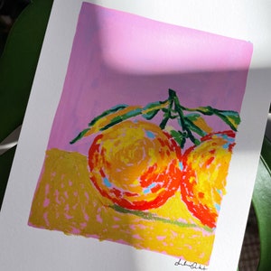 May include: A painting of two oranges with green leaves on a pink background. The oranges are painted in a stylised way with yellow, orange, and red colours.