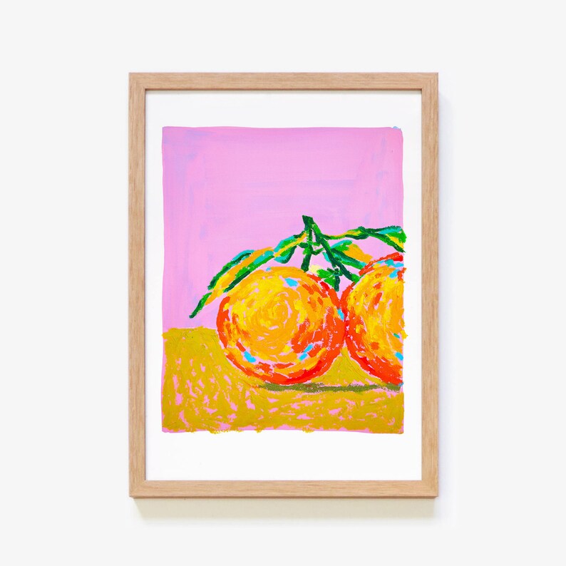 May include: A painting of two oranges with green leaves on a pink background. The oranges are painted in a bright orange and yellow colour with a hint of red. The leaves are painted in a bright green colour.