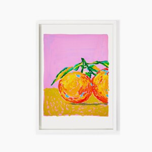 May include: Two bright orange oranges with green leaves on a pink and yellow background.
