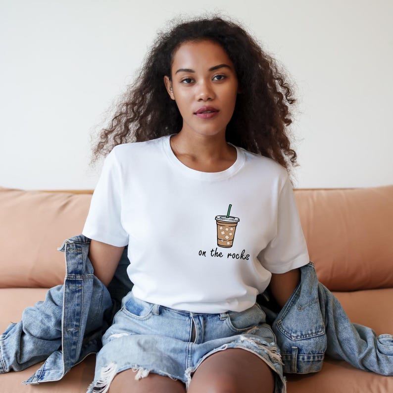 May include: White t-shirt with a brown and white iced coffee cup illustration and the text "on the rocks".
