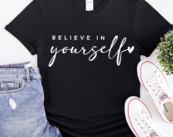 May include: Black t-shirt with white text that says "Believe in yourself" with a small heart symbol.