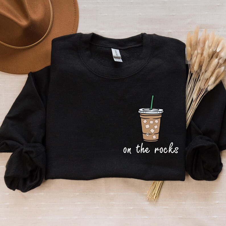 May include: Black sweatshirt with a white graphic of a coffee cup with ice and the text "on the rocks".