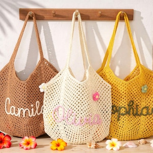 Puede incluir: Tres bolsos de ganchillo en marr&oacute;n, crema y amarillo, cada uno con un nombre personalizado bordado en letra cursiva. El bolso crema incluye peque&ntilde;as aplicaciones de flores, mientras que los bolsos marr&oacute;n y amarillo tienen patrones de punto abierto.