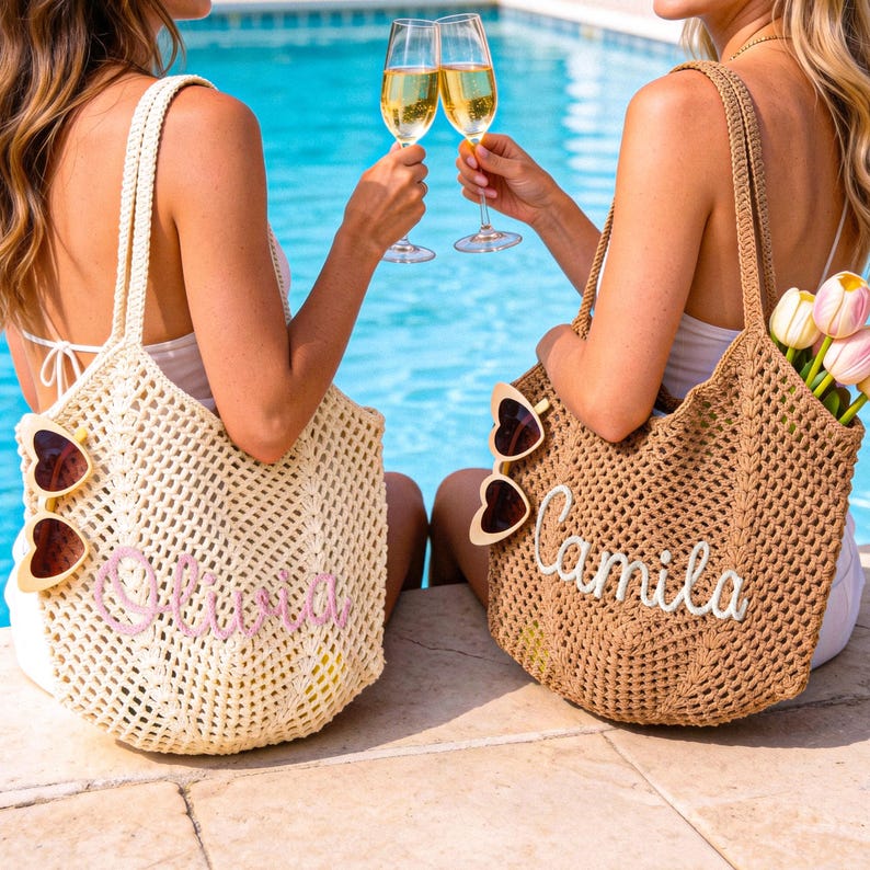 Puede incluir: Dos bolsos de ganchillo, uno color crema y otro tostado, cada uno con un nombre personalizado bordado en cursiva. El bolso crema muestra el nombre Olivia en rosa, mientras que el bolso tostado muestra Camila en blanco. Ambos bolsos tienen gafas de sol en forma de coraz&oacute;n.