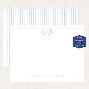 May include: A white stationery card with a light blue striped border, featuring the monogram C&D at the top center and the names CHARLOTTE & DAVID printed at the bottom. A dark blue hexagonal badge displays the text More Design & Color Options.