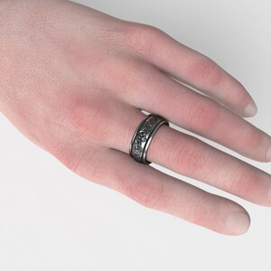 Puede incluir: Un anillo de plata con un dise&ntilde;o detallado en la banda.