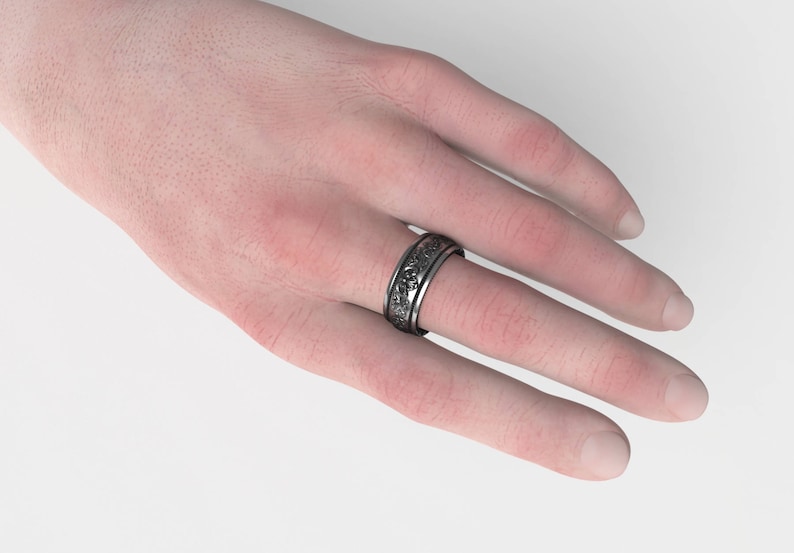 Puede incluir: Un anillo de plata con un dise&ntilde;o detallado en la banda.
