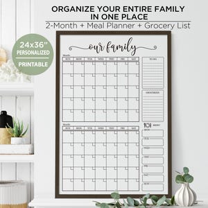 Pode incluir: Um planejador familiar imprimível de 61x91 cm emoldurado com uma moldura marrom escura. O planejador inclui um calendário de 2 meses, uma lista de compras e um planejador de refeições. O texto "Organize toda a sua família em um só lugar" está no topo.