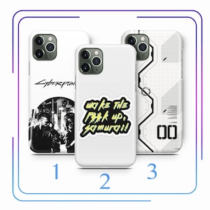 May include: Three white iPhone cases with different designs. The first case has a black and white image of a city skyline with the text "Cyberpunk" on top. The second case has a yellow sticker with the text "Wake the f**k up, Samurai!" The third case has a white and gray geometric pattern with the number "00" in the bottom right corner.
