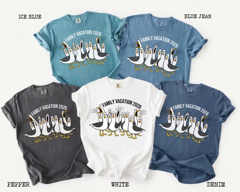May include: Five short-sleeve t-shirts in ice blue, blue jean, pepper, white, and denim colors. Each shirt features a graphic of multiple seagulls with open beaks and the text "FAMILY VACATION 2026" printed in an arc above the birds.