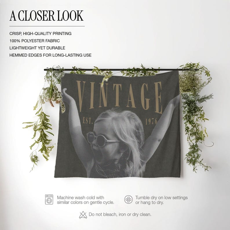 May include: A dark gray rectangular polyester wall tapestry featuring a black and white photograph of a child wearing round sunglasses with arms raised. The text VINTAGE EST. 1976 is printed in a tan serif font across the top of the image.