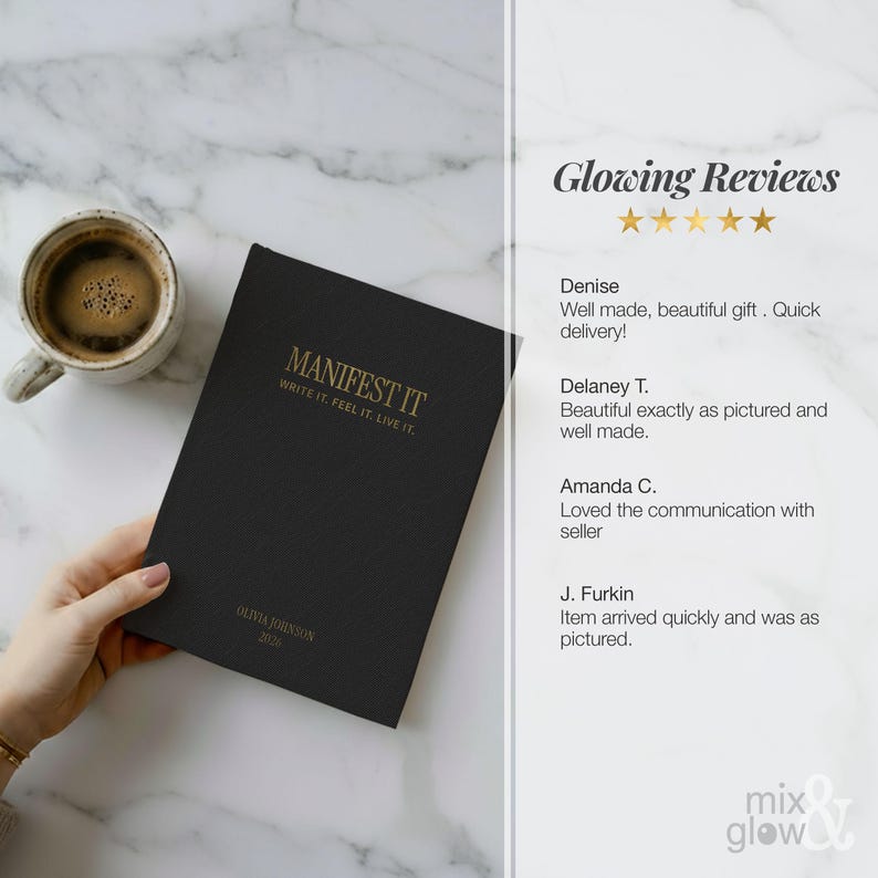May include: A black journal with gold lettering that reads "MANIFEST IT" and "WRITE IT. FEEL IT. LIVE IT." is held next to a cup of coffee. The journal also has the name "OLIVIA JOHNSON 2020" printed on it.