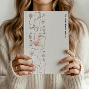 May include: A white notebook with a medical-themed border featuring illustrations of a stethoscope, pills, and a heart. The text "OLIVIA ANDERSON RN" is printed vertically on the right side of the notebook.