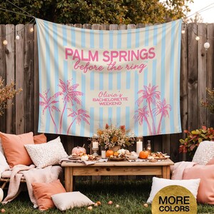 May include: A light blue and cream striped banner with pink text that reads "PALM SPRINGS before the ring" and "Olivia's BACHELORETTE WEEKEND". Pink palm tree graphics are also featured. The banner is hanging outdoors.