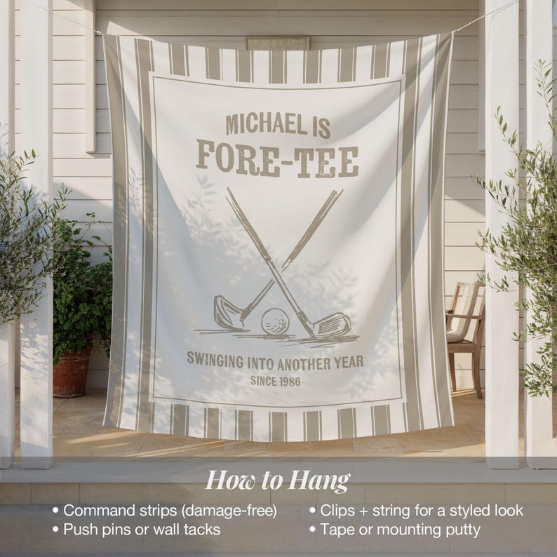May include: A white and beige golf-themed banner with the text "MICHAEL IS FORE-TEE" and "SWINGING INTO ANOTHER YEAR SINCE 1986". The design includes crossed golf clubs and a golf ball. The banner is hanging outside.