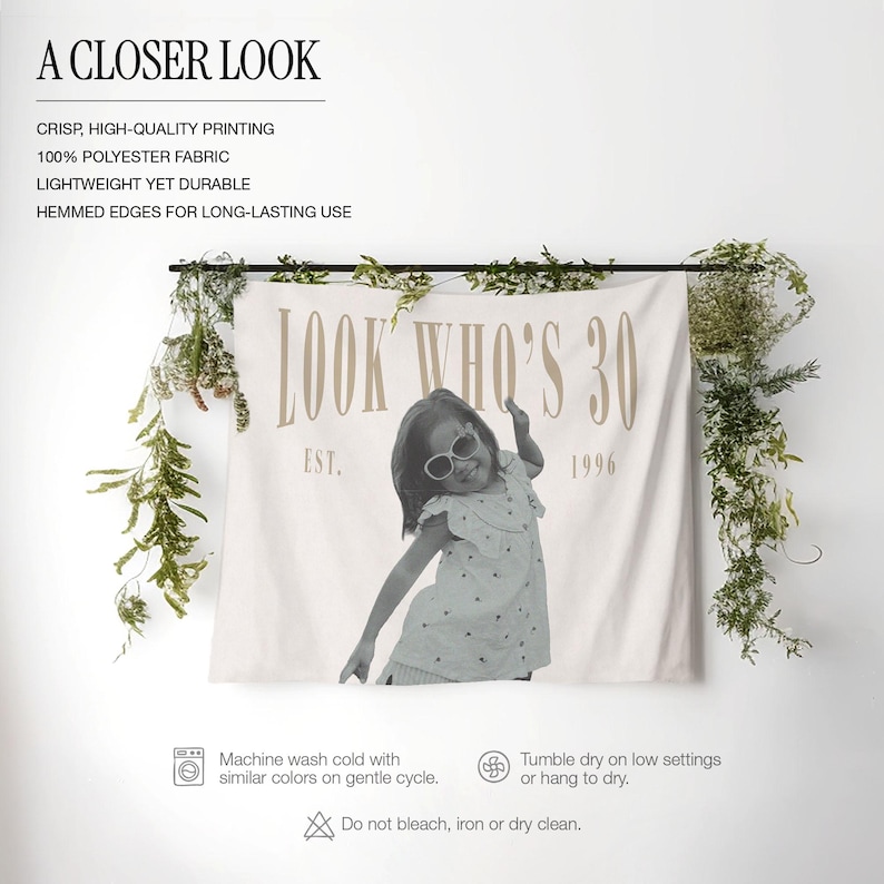 May include: A rectangular polyester wall tapestry featuring a black and white photograph of a child wearing sunglasses. The text reads LOOK WHO'S 30 and EST. 1996 in a tan serif font. The fabric is off-white with hemmed edges and is displayed hanging.