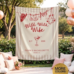 Puede incluir: Una pancarta a rayas beige y blancas con ilustraciones rojas de un sombrero de vaquero, lencer&iacute;a y botas colgadas de un tendedero. La pancarta dice "Wild Wild Wife" y "Olivia's Bachelorette, Miami, FL."