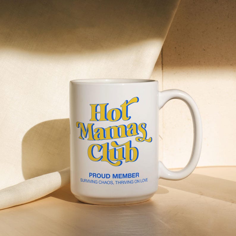 May include: A white ceramic mug with a black handle and the text "But First, Coffee" in a black, bold font. The mug is sitting on a wooden surface. The mug is approximately 4 inches tall.