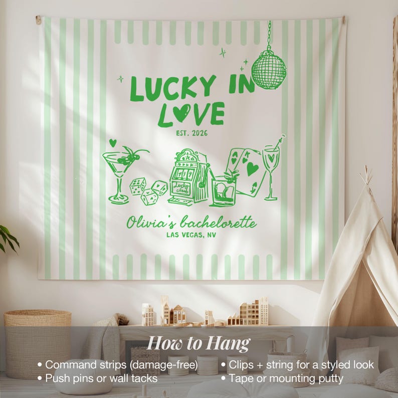 Pode incluir: Uma tape&ccedil;aria de parede branca com listras verticais verde claro. Apresenta texto e ilustra&ccedil;&otilde;es verdes, incluindo "LUCKY IN LOVE", um martini, dados, uma m&aacute;quina ca&ccedil;a-n&iacute;queis, cartas de baralho e uma bola de discoteca. O texto na parte inferior diz "Olivia's bachelorette, Las Vegas, NV."