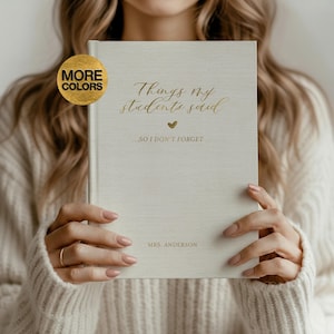 Puede incluir: Un diario de color crema con letras doradas que dice "Things my students said". El diario también tiene el texto "...SO I DON'T FORGET" y "MRS. ANDERSON". Un círculo dorado con las palabras "MORE COLORS" está en la esquina superior izquierda.