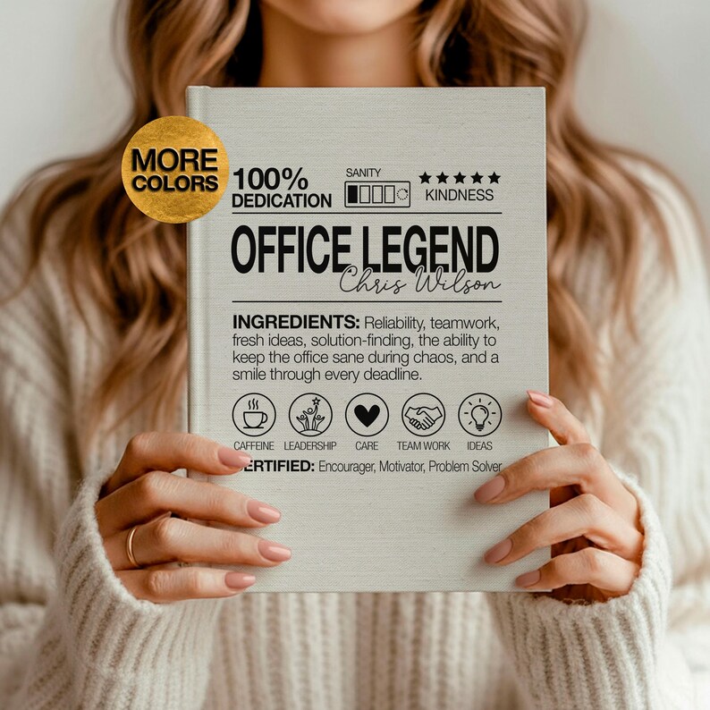 May include: A light-colored notebook with the words "OFFICE LEGEND" and "Chris Wilson" printed on the cover. The cover also includes the text "INGREDIENTS" and icons representing qualities like caffeine, leadership, and teamwork.