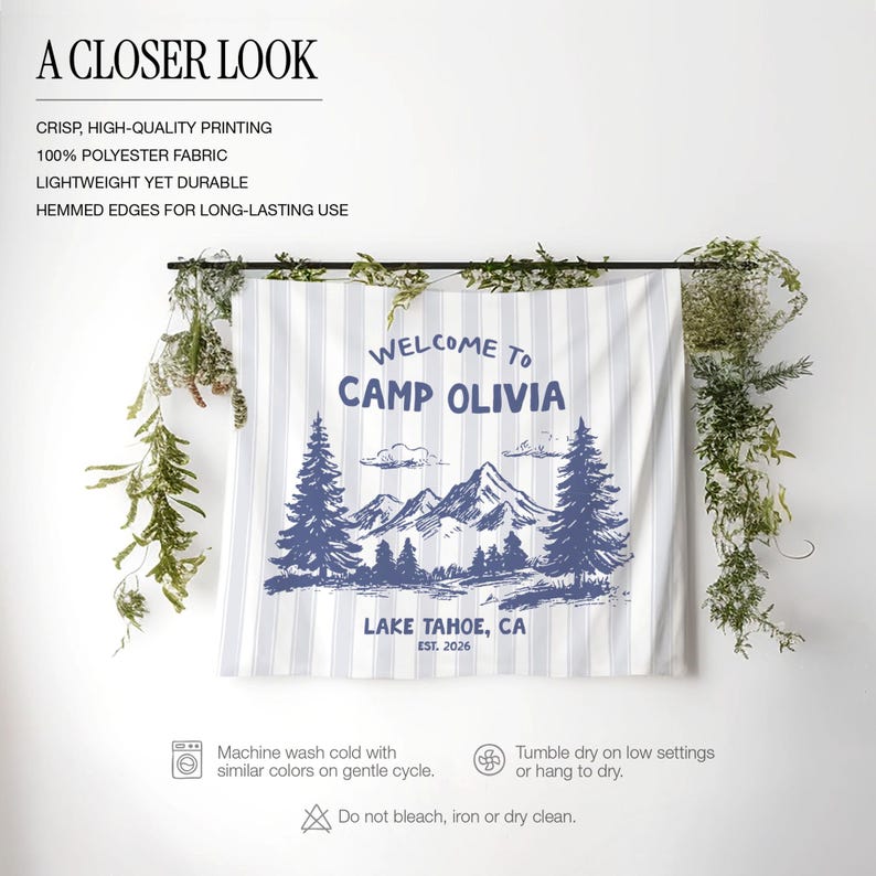 May include: A white and blue striped fabric banner with the text "WELCOME TO CAMP OLIVIA LAKE TAHOE, CA EST. 2026" and a mountain and pine tree graphic. The banner is made of 100% polyester fabric.