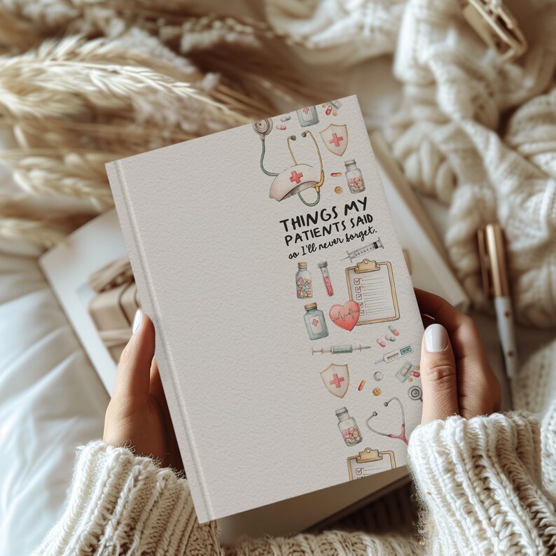 K&ouml;nnte beinhalten: Ein cremefarbenes Notizbuch mit dem Text "THINGS MY PATIENTS SAID so I'll never forget." Das Notizbuch zeigt medizinische Illustrationen, darunter ein Stethoskop, ein Herz und Medikamentenflaschen. Das Notizbuch wird von einer Person gehalten, die einen cremefarbenen Pullover tr&auml;gt.