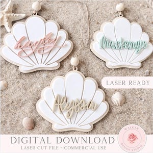 Puede incluir: Tres adornos en forma de concha blanca con bases de madera y cuentas colgantes. Cada uno presenta un nombre en cursiva: hayley en rosa claro, Mackenzie en verde claro y Alyssa en beige. Se observa el texto LASER READY y DIGITAL DOWNLOAD.