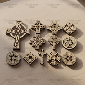 Peut inclure: Une collection de croix celtiques en bois découpées au laser, avec différents motifs. Les croix présentent des motifs de nœuds complexes et varient en taille et en forme, avec une couleur bois clair et des détails gravés plus foncés.