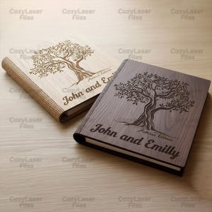 Może przedstawiać: Dwa drewniane dzienniki z grawerowanymi wzorami drzew. Jeden jest jasny z tkanym grzbietem, drugi ciemnobrązowy. Oba mają wygrawerowane imiona "John and Emilly" na okładce, z tekstem "Juterus hitteric" poniżej.