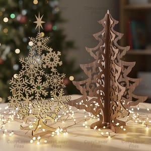 May include: Two wooden Christmas tree decorations. One is gold-colored and shaped like a snowflake, topped with a star. The other is brown, with an openwork design. Both are illuminated by a string of warm white lights, creating a festive holiday scene.