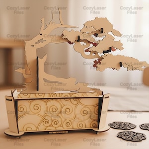May include: A wooden bonsai tree model with a decorative pot and coasters. The tree has a detailed, layered design with reddish-brown accents on the leaves. The pot features a swirling pattern. The coasters have a similar design.