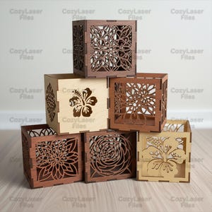 Könnte beinhalten: Eine Sammlung von lasergeschnittenen Holzwürfelboxen mit aufwendigen Blumen- und Hibiskusdesigns. Die Boxen sind in verschiedenen Braun- und Naturholztönen gehalten, mit dem Text "CozyLaser Files" sichtbar. Diese dekorativen Boxen sind ideal für die Inneneinrichtung.