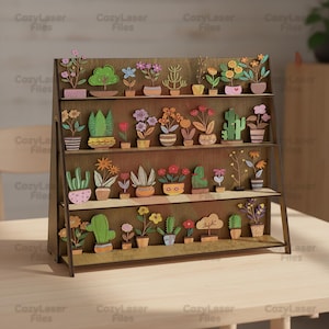 Puede incluir: Una estantería de madera con tres niveles, que muestra numerosas plantas en macetas de madera cortadas con láser y coloridas. Las plantas incluyen varias flores y cactus, con el texto "CozyLaser Files" repetido en los lados.