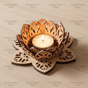 May include: A laser-cut wooden lotus flower candle holder with a lit tea light. The holder features detailed patterns and is made of light brown wood. The candle flame is bright. The text "CozyLaser Files" is visible on the image.