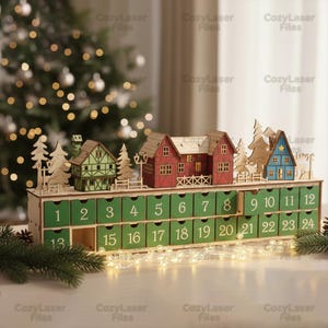 Könnte beinhalten: Weihnachts-Adventskalender aus Holz mit 24 nummerierten, grün lackierten Schubladen. Der Kalender zeigt Miniatur-Holzhäuser und Bäume auf der Oberseite. Die Häuser sind rot, grün und blau bemalt. Lichterketten und Tannennadeln schmücken die Oberfläche.