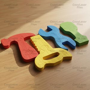 Könnte beinhalten: Holzpuzzles in Form von Werkzeugen in Rot, Gelb, Blau und Grün. Das Set enthält einen Hammer, eine Säge, einen Schraubenschlüssel und ein grünes Werkzeug. Die Werkzeuge liegen auf einer hellbraunen Holzoberfläche. Der Text "CozyLaser Files" ist sichtbar.