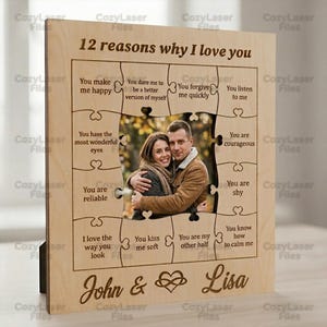May include: A wooden photo frame in the style of a jigsaw puzzle, engraved with "12 reasons why I love you." It features a couple's photo and phrases such as "You make me happy." The names "John & Lisa" are also engraved on the frame.