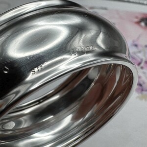 Op de afbeelding: Zilveren servetring met de inscriptie "STER 925" aan de zijkant.