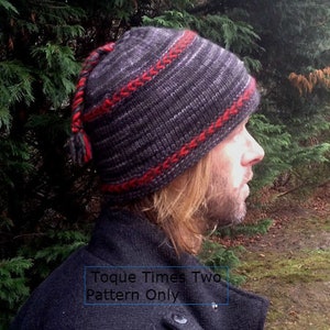 May include: A black and red striped toque with a long braid hanging down the back. The toque has the text "Toque Times Two Pattern Only" on the front.