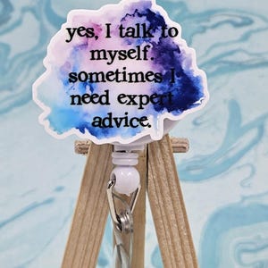 May include: A blue, purple, and pink watercolor badge reel with the text "yes, I talk to myself. sometimes I need expert advice."