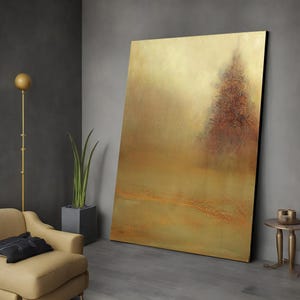 May include: Abstract landscape painting with a golden background and a single tree in the center. The tree is a dark brown color and is surrounded by a hazy, golden atmosphere.