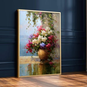 以下が含まれることがあります： テラコッタの鉢に活気のある花の配置が描かれた額入りの絵画。花は赤、白、紫が混ざり合い、緑の葉があります。背景には、青い空と水のある海岸の風景が描かれています。