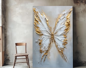 May include: A large canvas artwork depicting a butterfly with white wings and gold detailing, set against a light grey backdrop. The textured butterfly art is displayed in a room with a wooden chair. The artwork is a decorative piece.