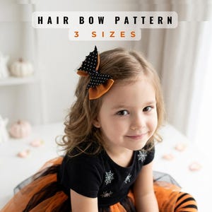 May include: A hair bow pattern with 3 sizes text. The hair bow is black with white polka dots and orange fabric, shaped like bat wings. The black shirt features white spider web and spider graphics, paired with an orange and black tulle skirt.