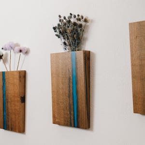 May include: A set of three ceramic vases in varying heights. The vases have a matte finish in shades of cream, beige, and brown. The tallest vase is approximately 10 inches high.