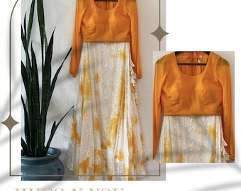 Può includere: Una gonna stampata bianca e gialla con una blusa gialla a maniche lunghe abbinata. La gonna ha un orlo arricciato e la blusa ha una scollatura rotonda. Il testo "HUES N YOU COLLECTION" e "SHOP NOW" è visibile nell'immagine.